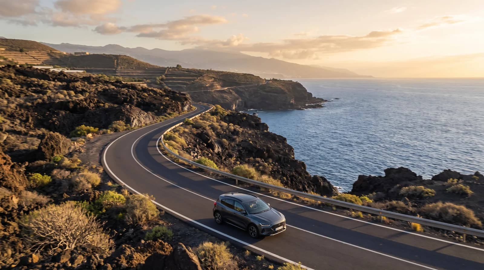 Un coche en una carretera costera de Tenerife al atardecer